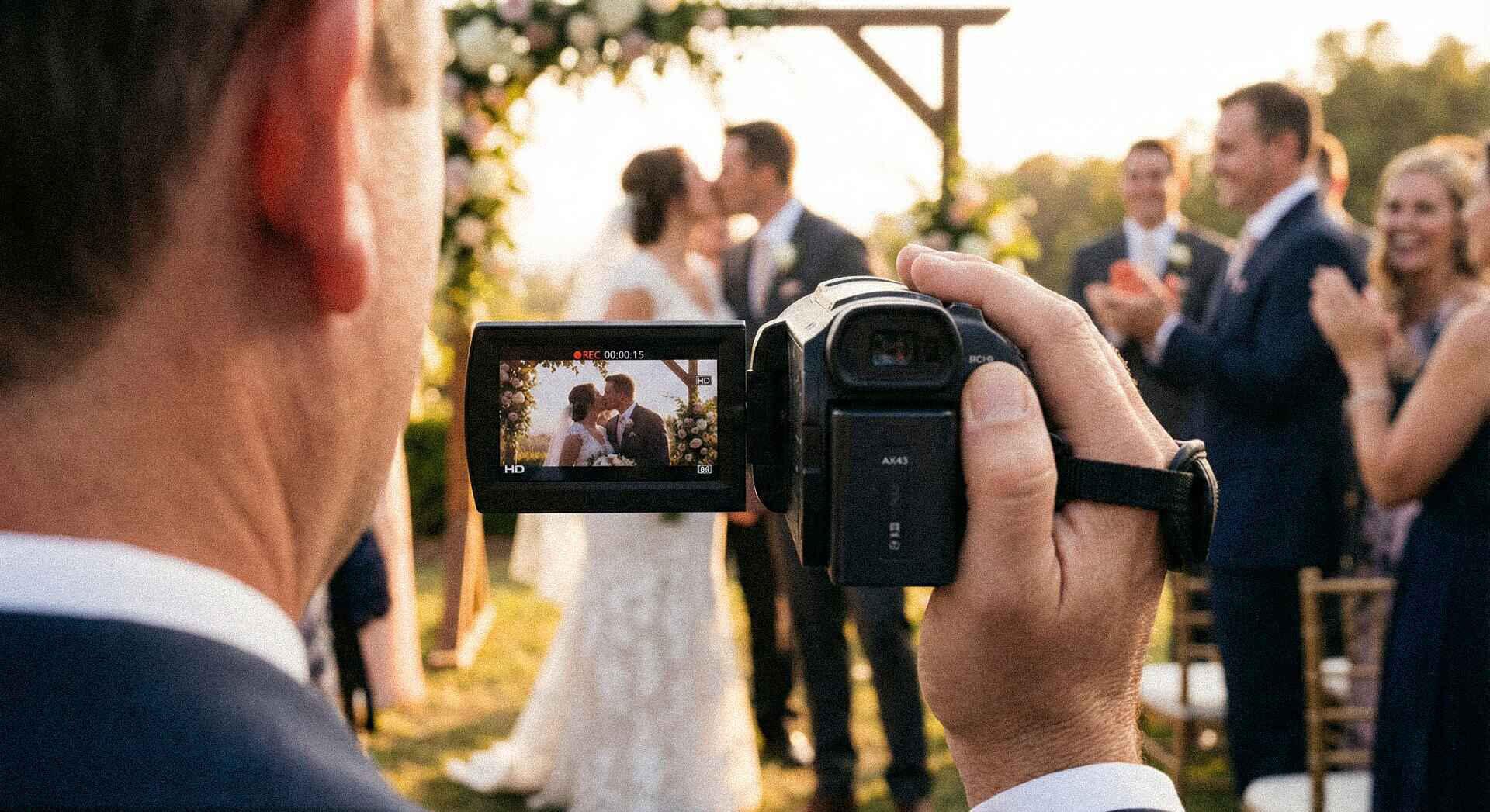 A wedding guest filming the couple's first kiss on a WeddingCam camcorder